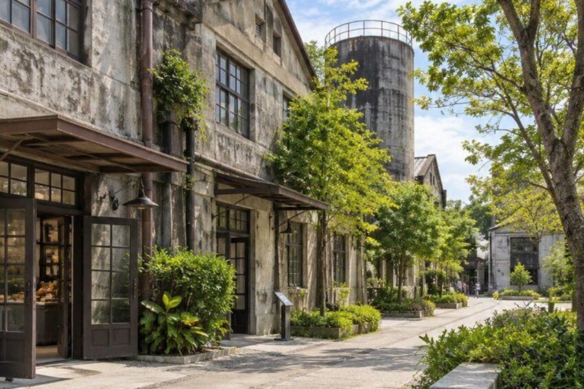 A historic building with large windows and a silo in the background. 3