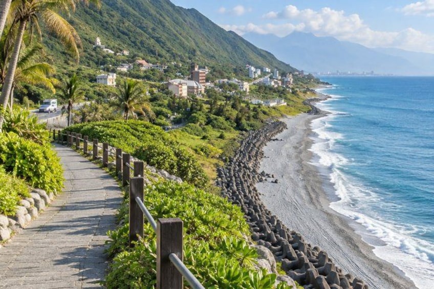 A coastal walkway with a wooden railing, a rocky beach, and a mountain backdrop. 5