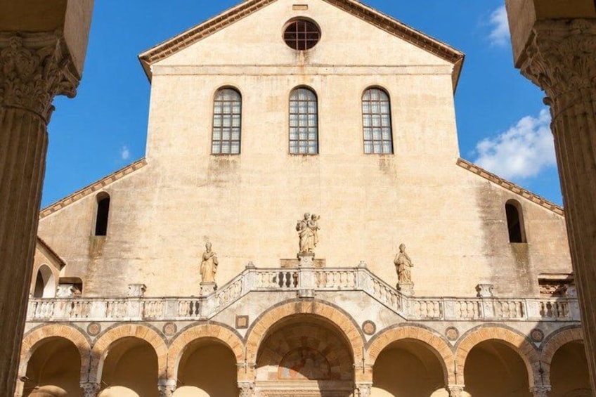 A historical building with a central dome, arched windows, and statues. 4