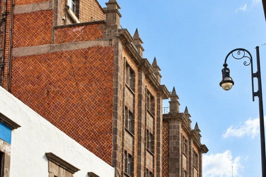 A historic building with a brick facade and a white building in the foreground. 2