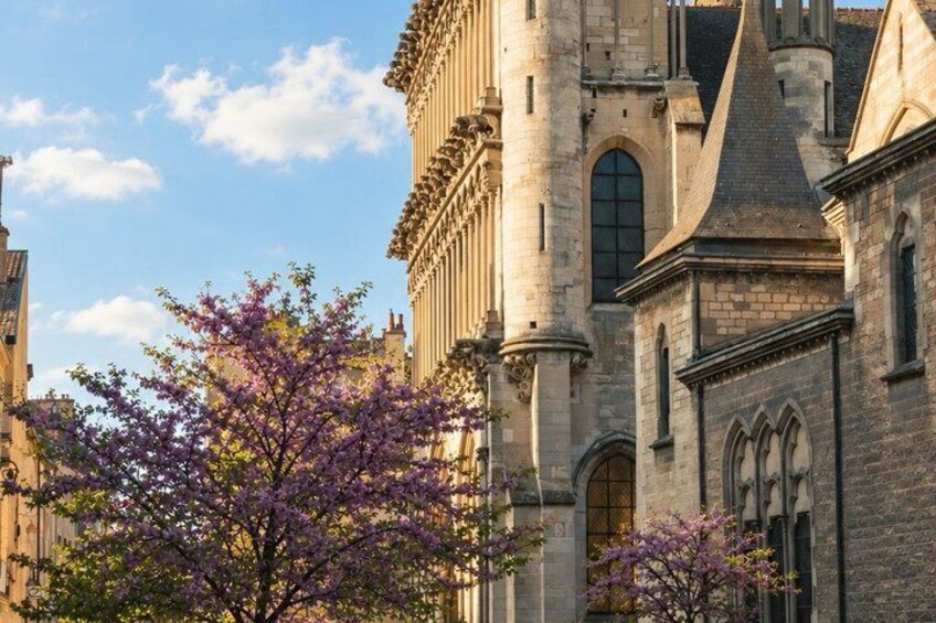 A historic building with intricate architecture, including a tower and arched windows. 2