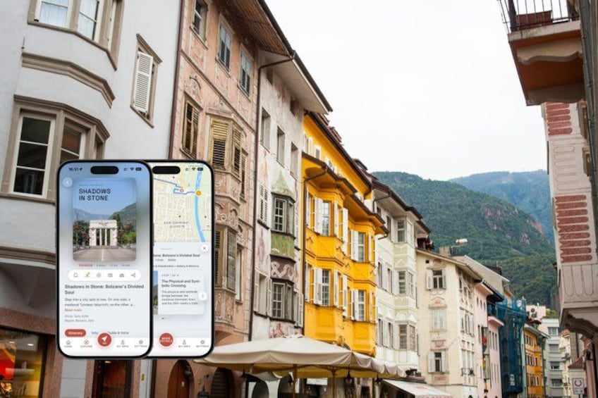 A street with colorful buildings, a smartphone displaying a map, and a mountain in the background. 1