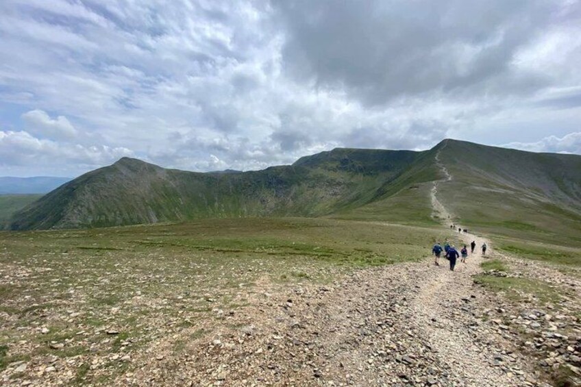 A mountainous landscape with a rocky path and a group of hikers. 3