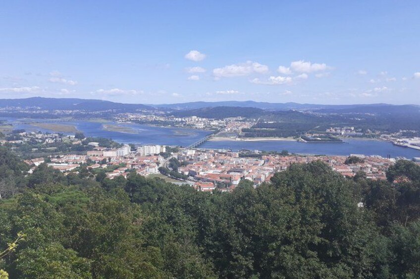 A coastal city with a river, dense greenery, and distant mountains. 4