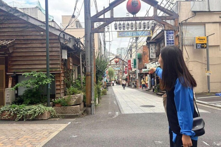A narrow street with traditional wooden buildings, a pedestrian crossing, and a sign for 'Times' to the right. 2