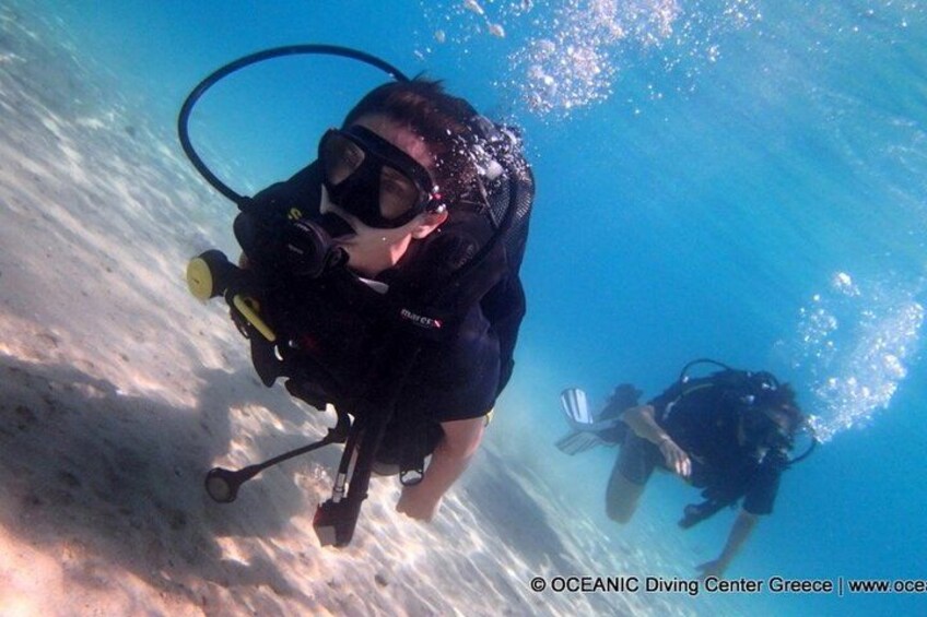 Two scuba divers underwater with fins and scuba gear. 5