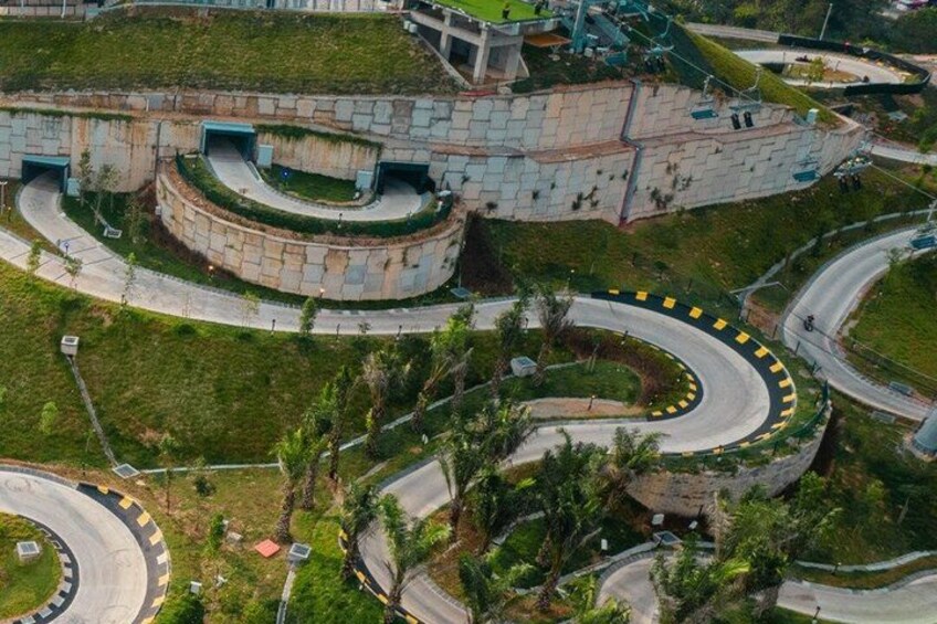 A complex road interchange with multiple loops and ramps, surrounded by greenery and palm trees. 4
