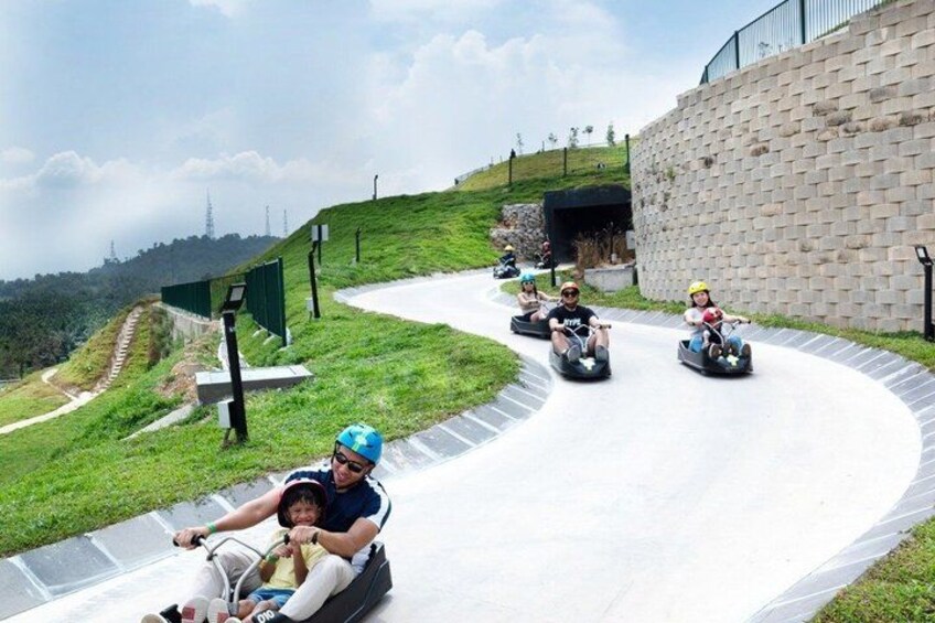 People on a winding track with a brick wall and greenery in the background. 1