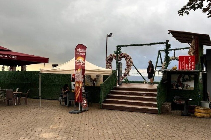 A paved area with a tent, a flag, a staircase, and a small kiosk. 2
