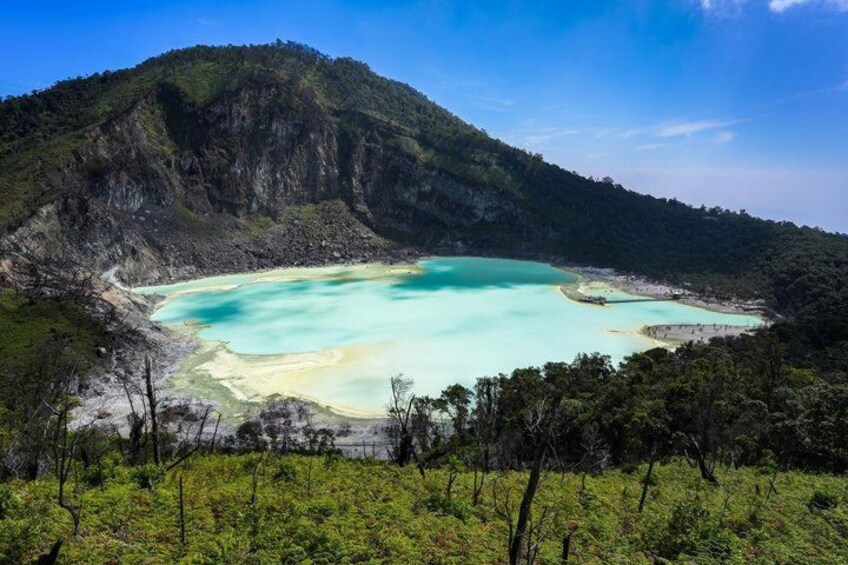A turquoise lagoon surrounded by forested hills. 3