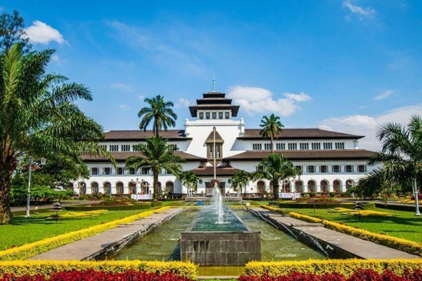 A large white building with a central fountain, surrounded by well-maintained gardens and palm trees. 4