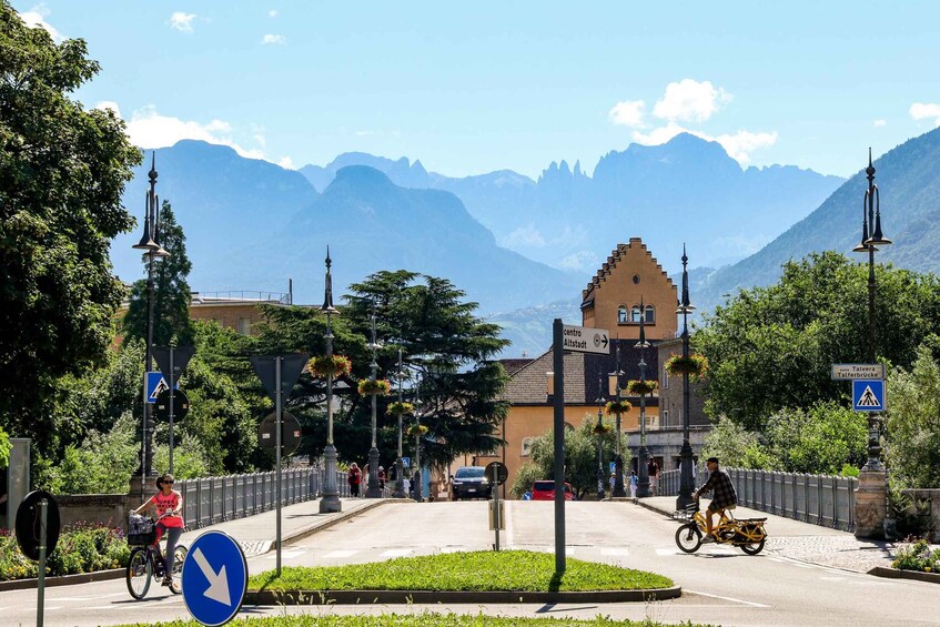 A town square with a prominent church, a pedestrian crossing, and a cyclist. 1