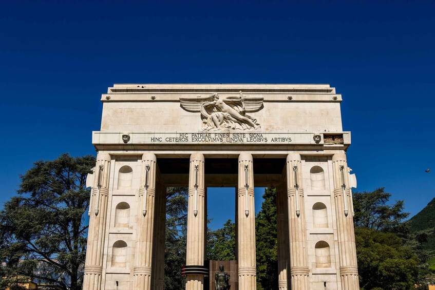 A large stone monument with inscriptions and a sculpture of a winged figure. 4