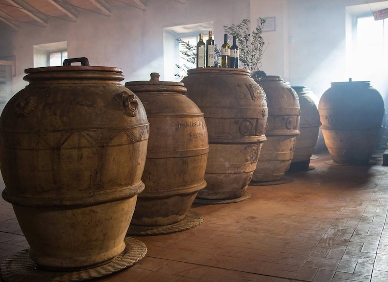 Large wooden barrels lined up in a room with a tiled floor. 1