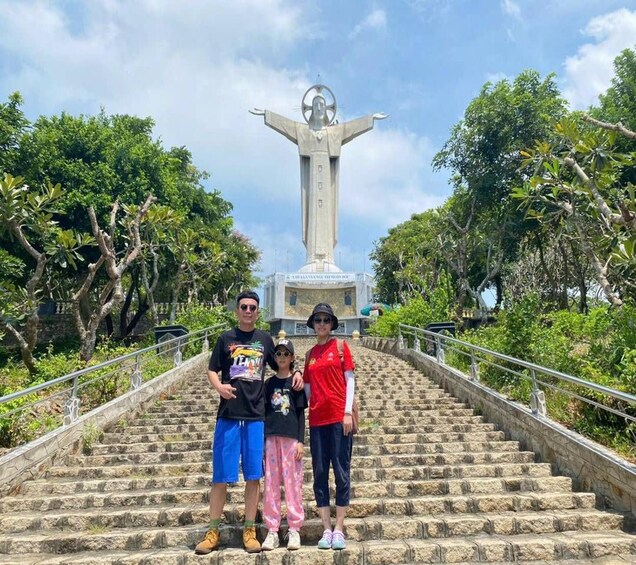 Una familia posa en escalones de piedra con una estatua al fondo. 2