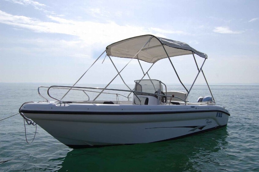 Un bateau à moteur blanc, doté d’un auvent, flotte sur l’eau. 5