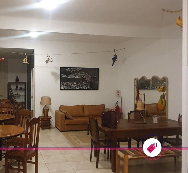 A living room with a brown sofa, wooden dining table, chairs, a lamp, and a zebra print artwork on the wall. 2