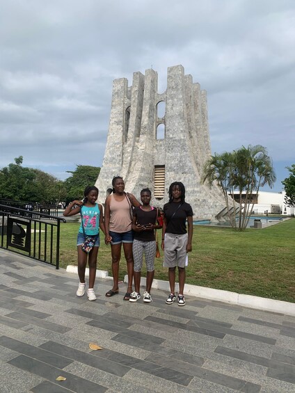 A group of people standing in front of a large stone monument with a staircase leading up to it. 5