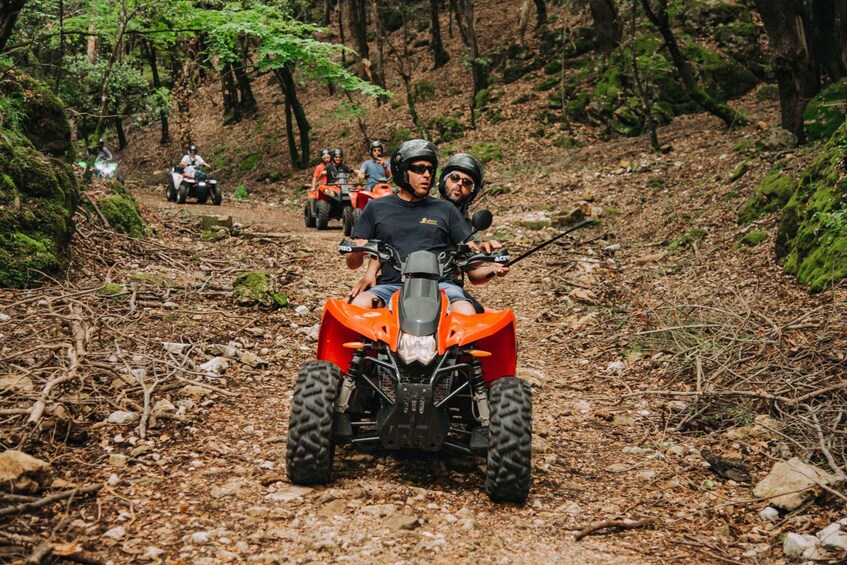 A group of people on ATVs on a forest trail. 1