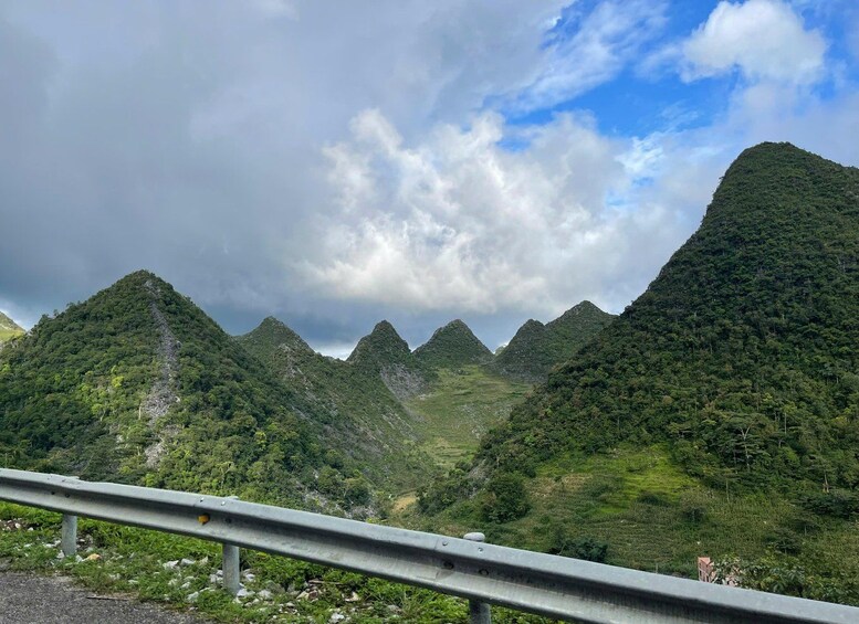A mountainous landscape with a guardrail in the foreground. 5