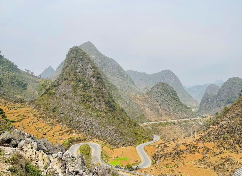 A winding road through a mountainous landscape with rocky terrain and sparse vegetation. 4
