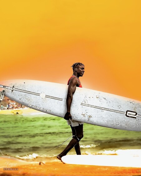 A person carrying a surfboard. 1