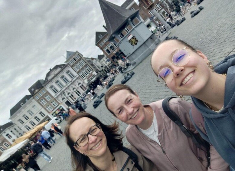 A group of people in a public square with historic buildings and a coat of arms. 3