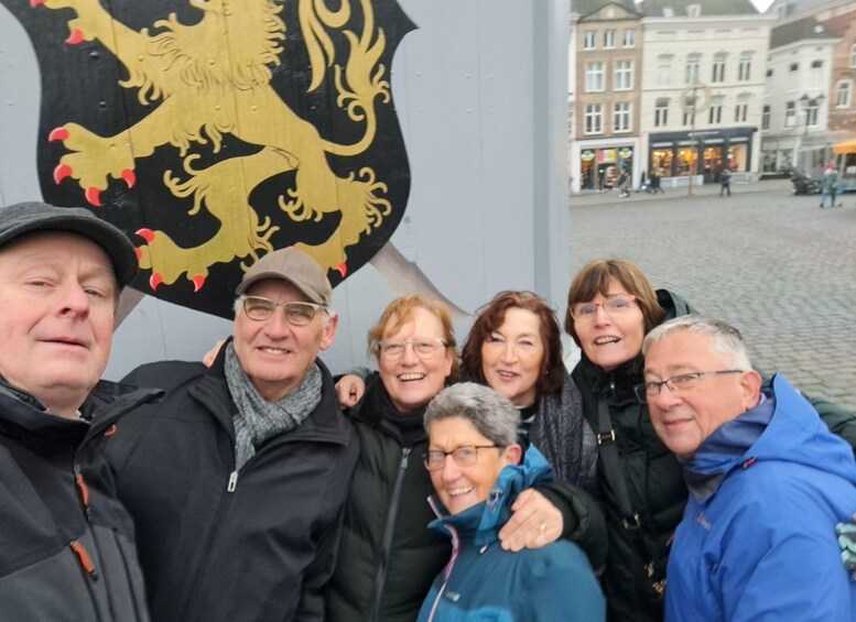 A group of people posing in front of a coat of arms. 2