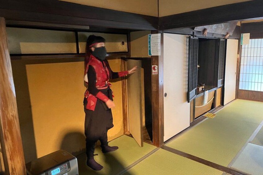 A person in traditional attire standing in a room with tatami flooring and sliding doors. 2