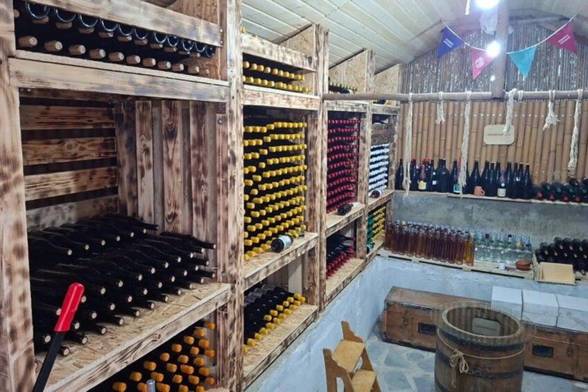 A wooden wine cellar with shelves of wine bottles. 2