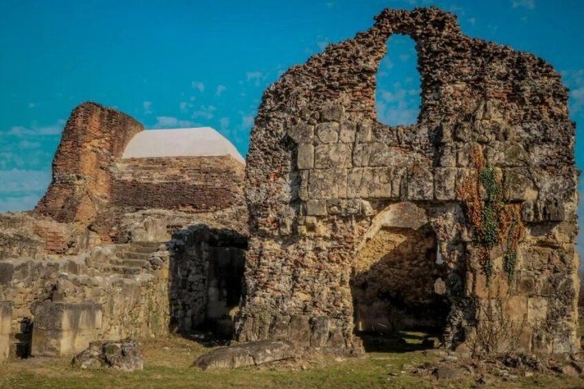 Ancient stone ruins with arches and a partially intact wall. 4