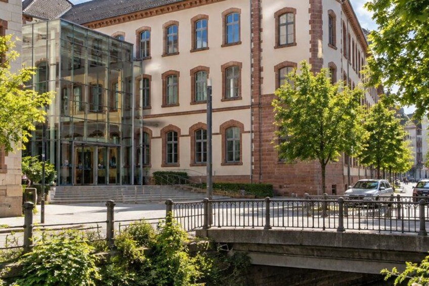 A building with a glass facade, a brick structure, and a bridge. 3