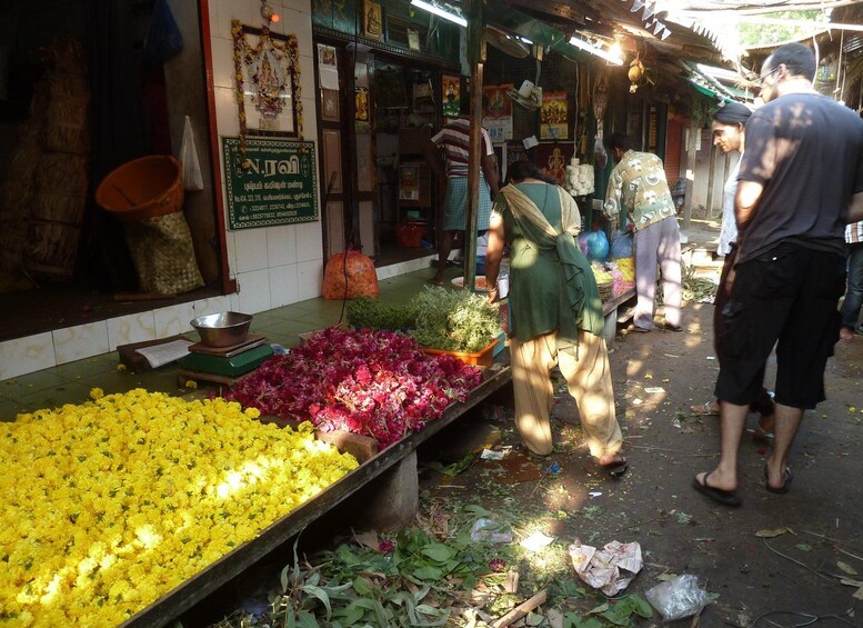 Un puesto de mercado con flores y un letrero. 3