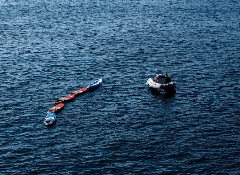 Una fila de kayaks y un bote a motor en aguas tranquilas. 1