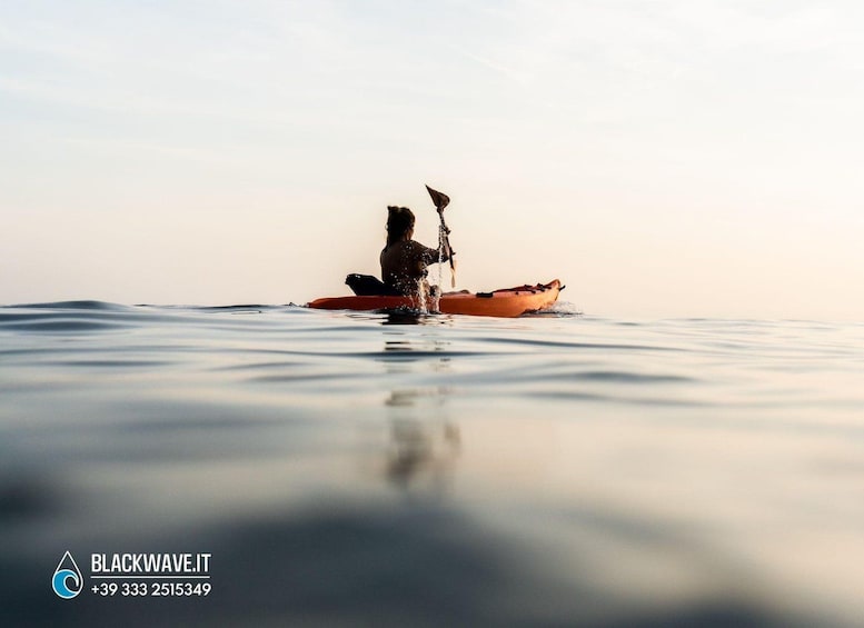 Una persona haciendo kayak en aguas tranquilas durante el atardecer. 2