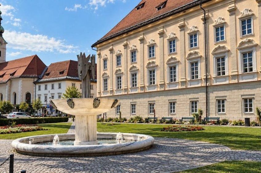 A classical building with a fountain in front. 4