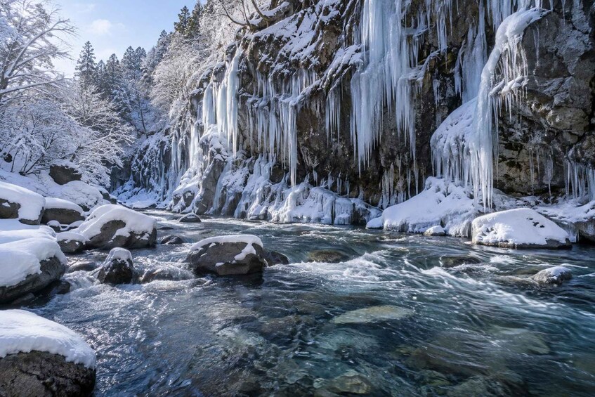 A snowy river with ice formations and rocks. 1