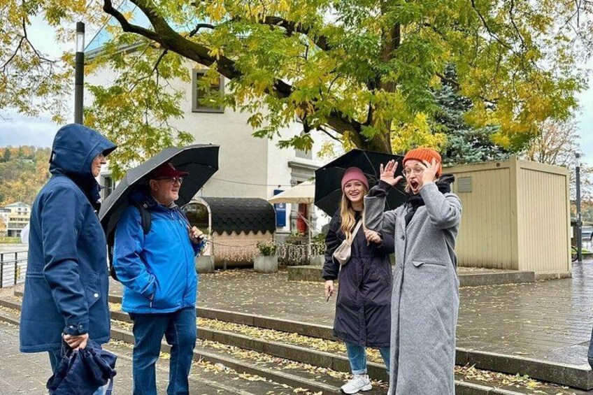Four people standing on a wet sidewalk, holding umbrellas. 3