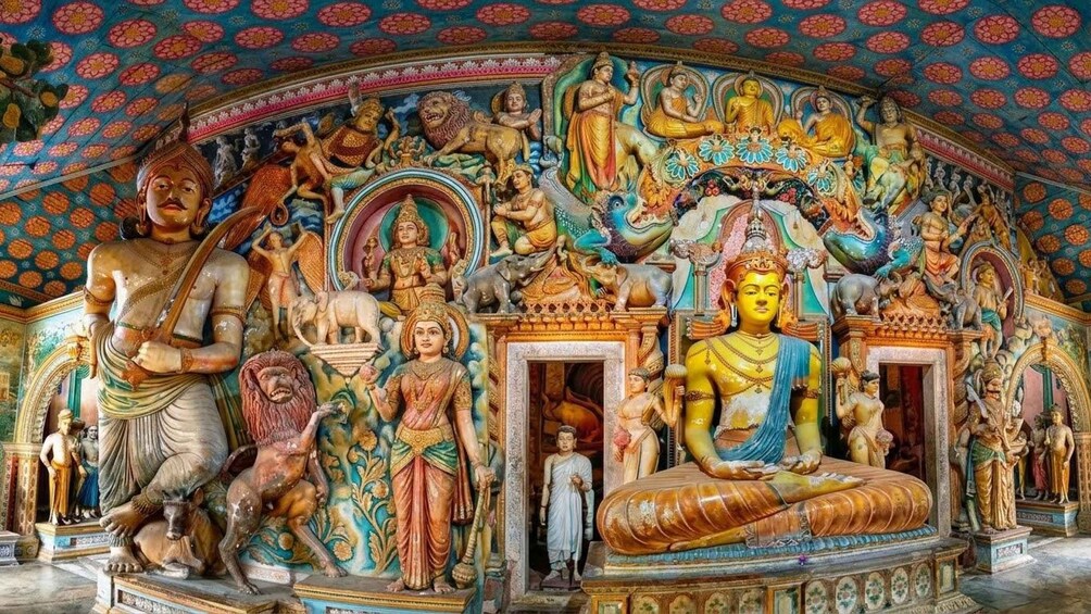 Der Innenraum eines Tempels mit aufwendigen Schnitzereien, Statuen und einer großen Buddha-Figur in der Mitte. 5