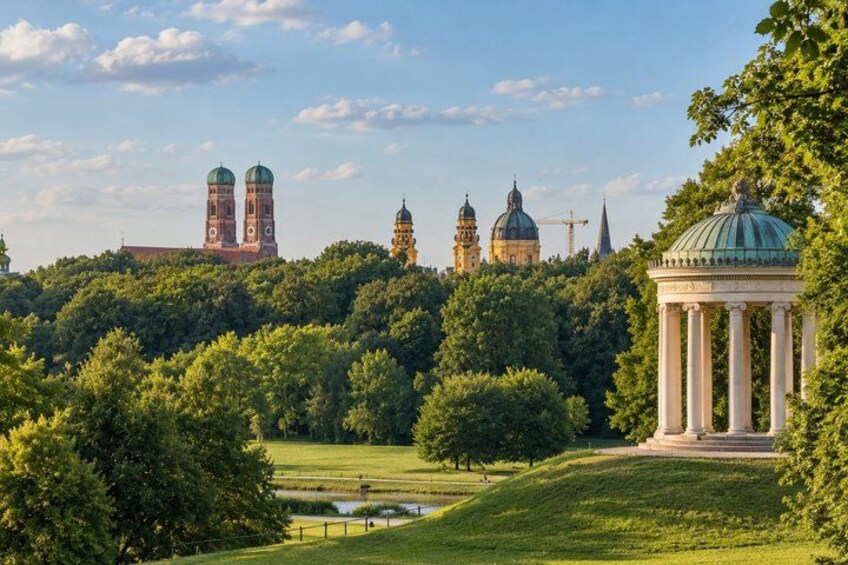A park with a gazebo, a pond, and historic buildings in the background. 4