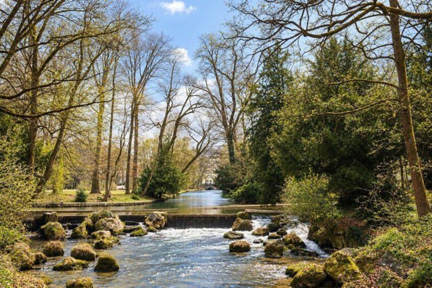 A river with rocks, surrounded by trees and greenery. 2