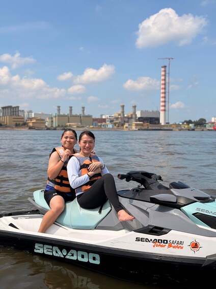 Deux personnes sur un jet ski Sea-Doo, avec une vue sur la ville en arrière-plan. 3
