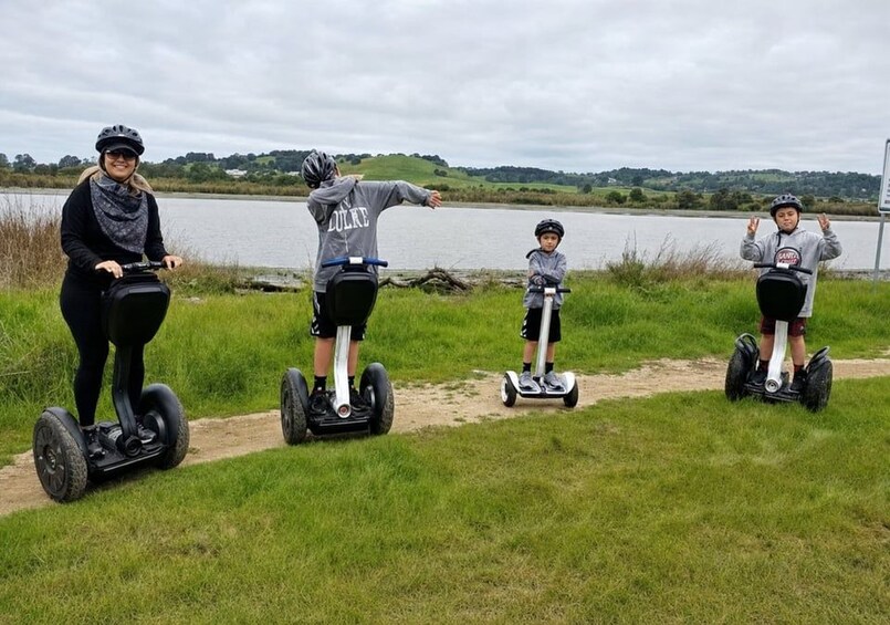 Four people on segways by a lake. 5
