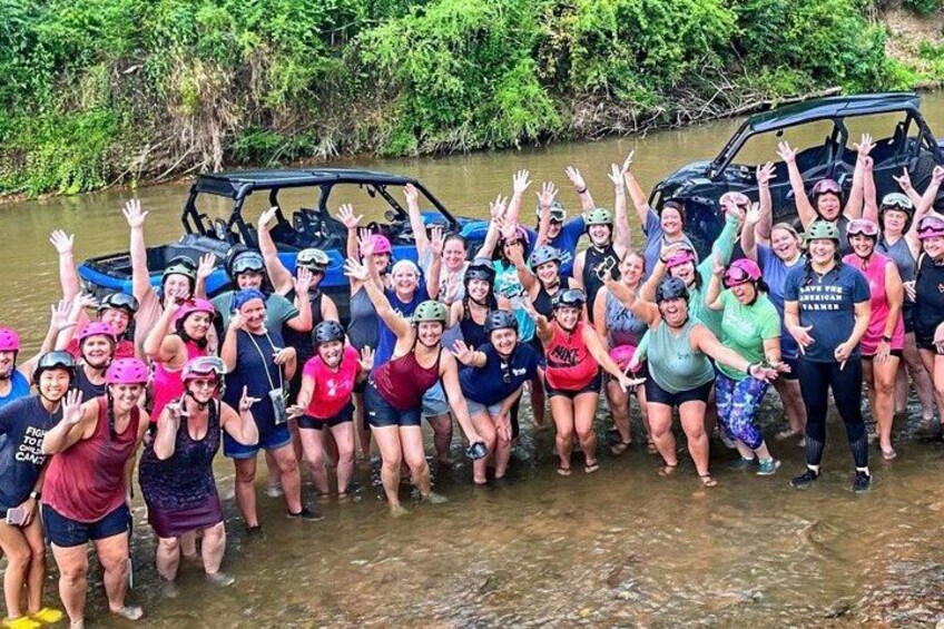 A group of people in a river with a vehicle. 1
