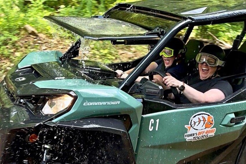 A green off-road vehicle with a windshield wiper, a logo, and a sticker on the side. 5