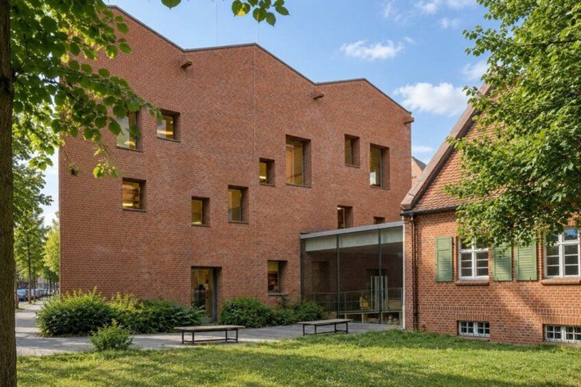 A red brick building with multiple windows and a glass entrance. 2