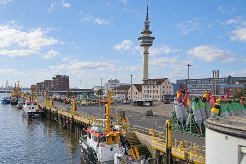 A harbor with boats, a tower, and industrial buildings. 4