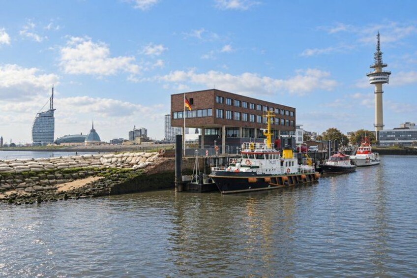 A river with boats, a modern building, and a tower in the background. 3