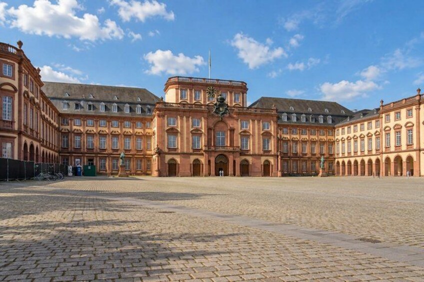 A large, historic building with a central courtyard, surrounded by brick walls and multiple windows. 3