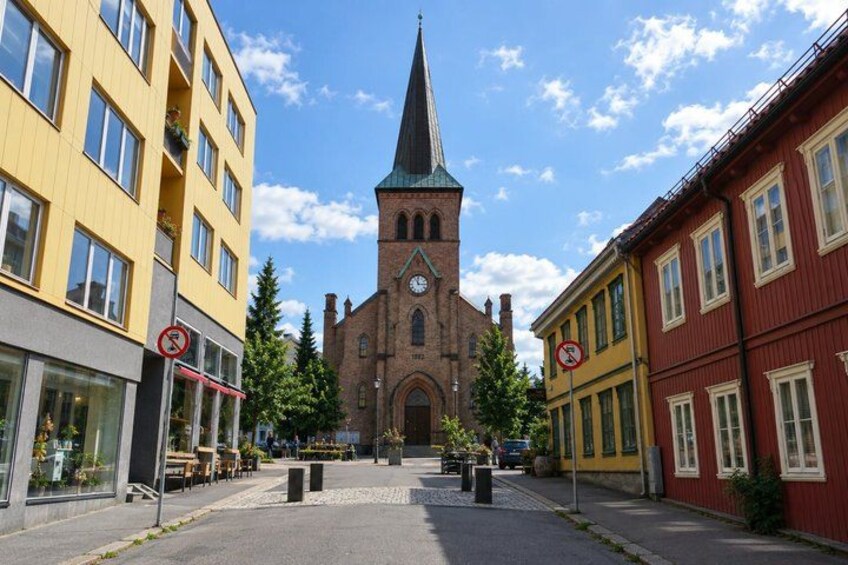A street with buildings, a church, and a no parking sign. 4